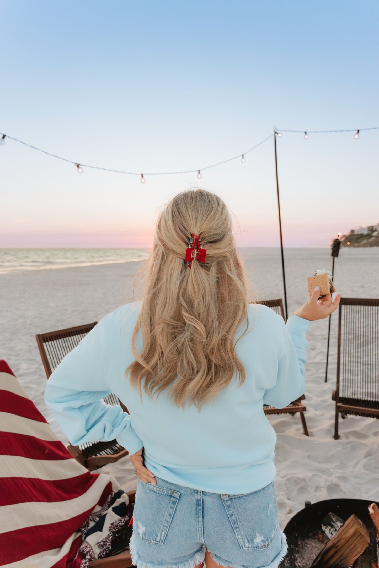 red clip in blonde hair on beach