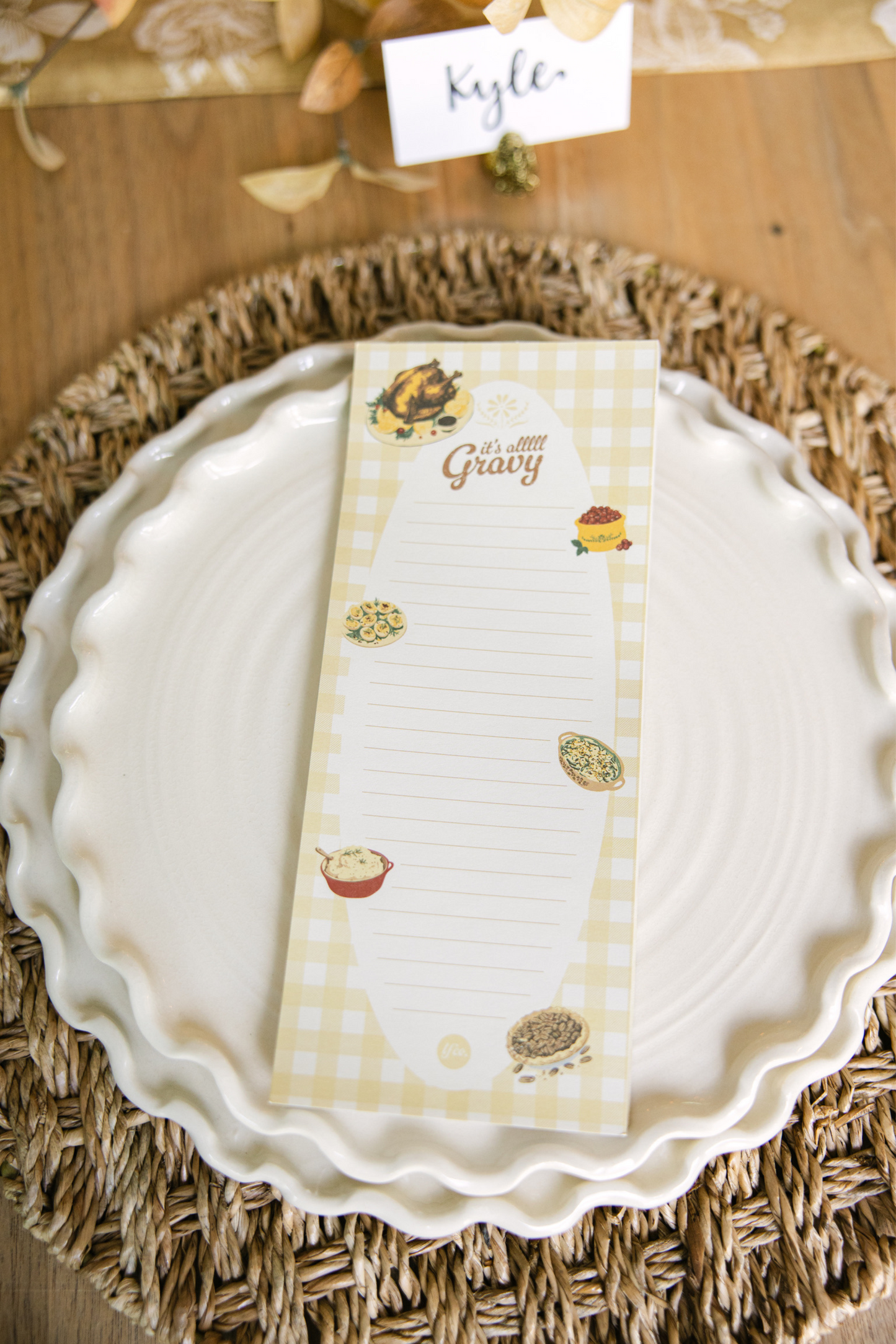 White plate with a decorative placemat featuring food illustrations on a wooden table.