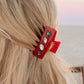 red claw clip with stones in blonde hair