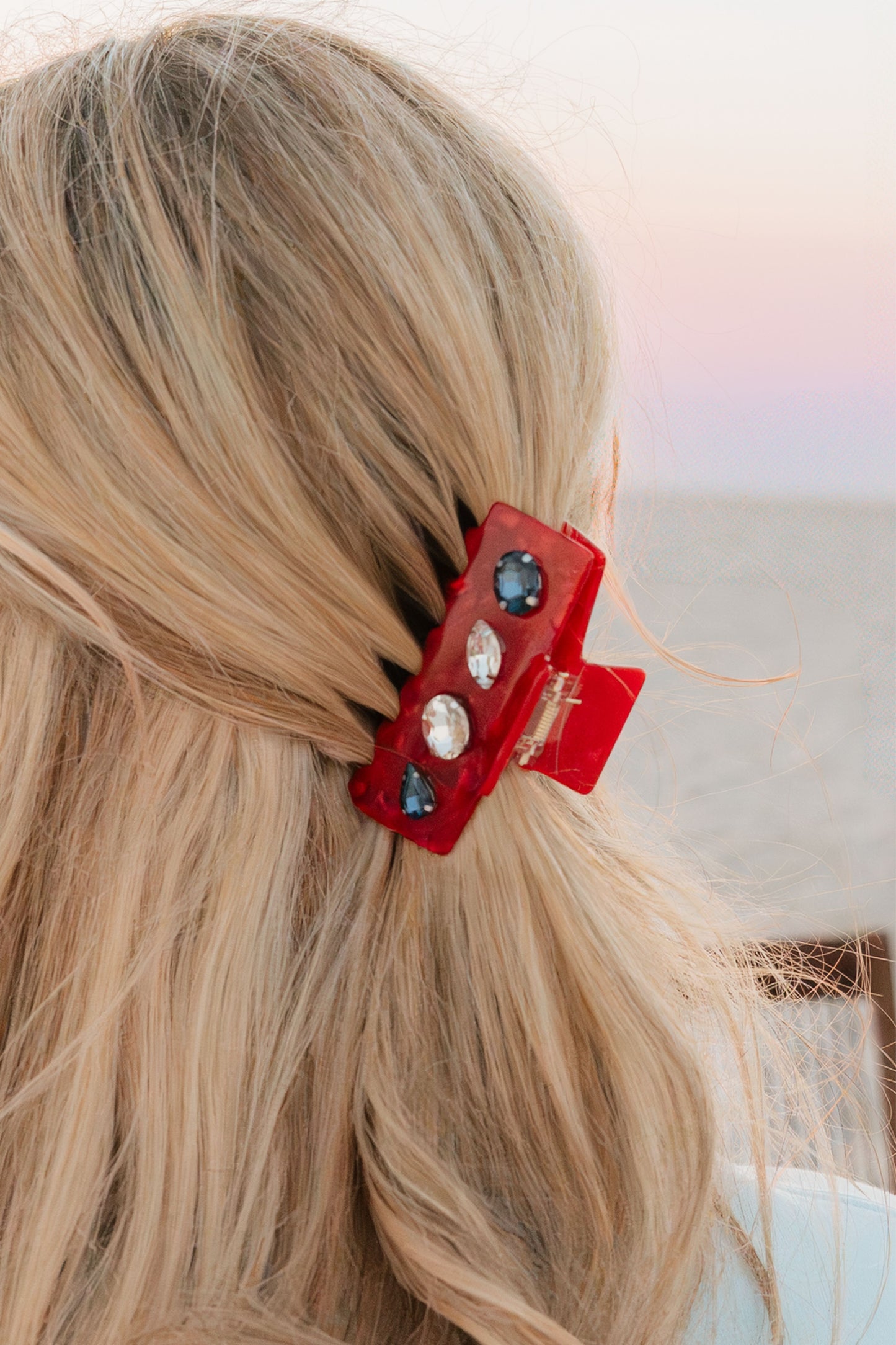 red claw clip with stones in blonde hair