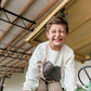 kid wearing turkey sweatshirt smiling on tractor