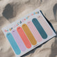 Colorful notepad with sticky notes on a sandy surface
