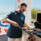 Man grilling outdoors with a scenic background