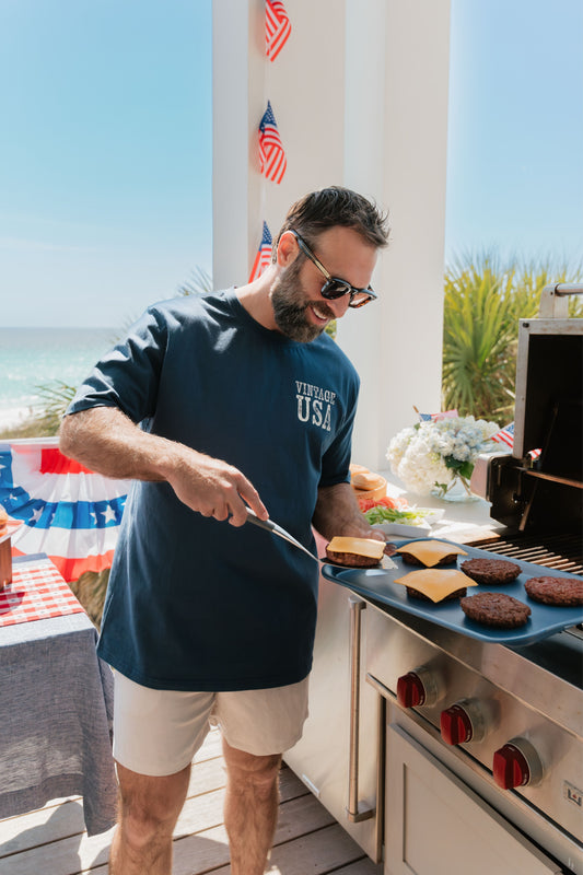Man grilling outdoors with a scenic background