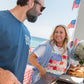 Man and woman grilling outdoors with American flags in the background
