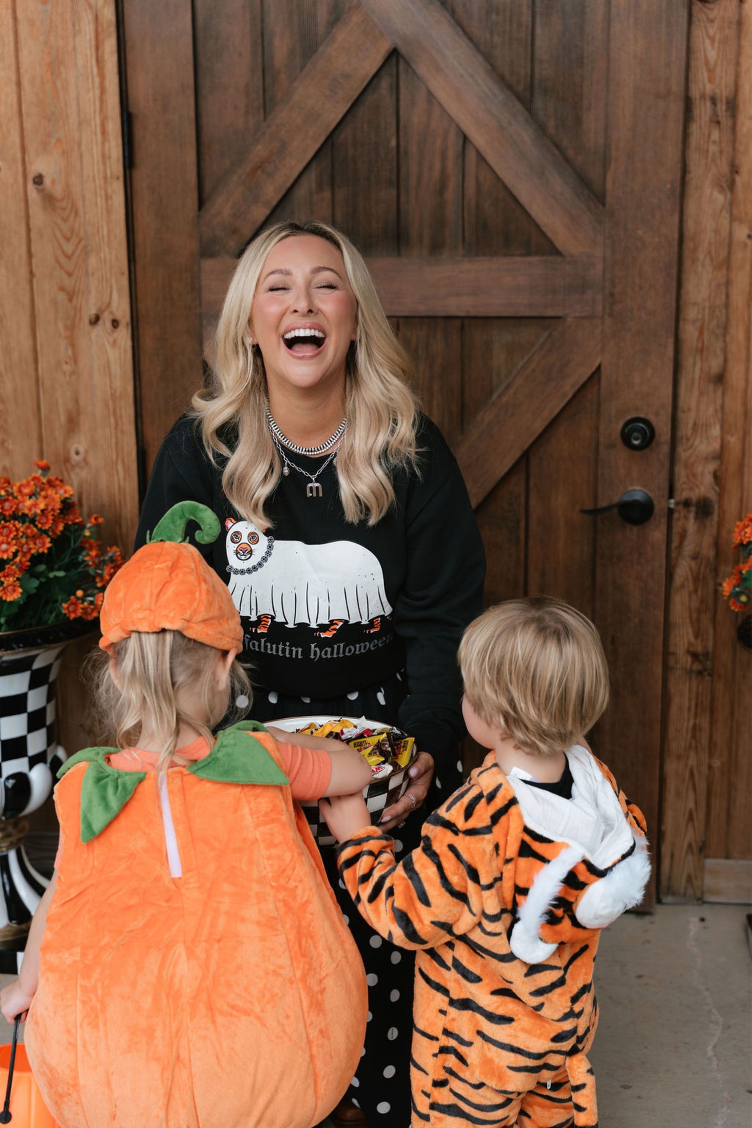 woman giving out candy to kids in costume