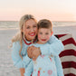 woman and kids on beach at bonfire wearing light blue firework sweatshirt 