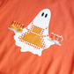 Spiced orange sweatshirt with a ghost holding candy corn design on a plain background