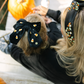 Woman and child wearing decorative hair accessories with pumpkins in the background.