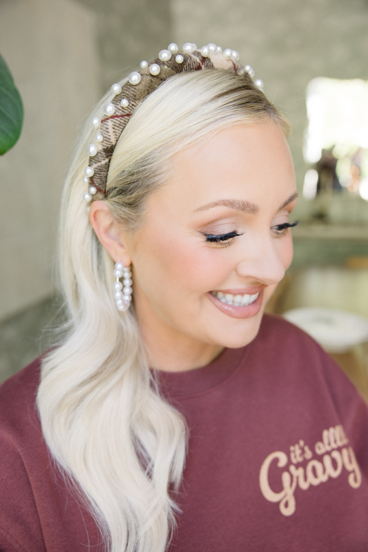 Woman wearing a pearl headband and smiling