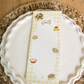 White plate with a decorative placemat featuring food illustrations on a wooden table.