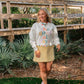 Woman wearing a colorful 'the good old days' sweatshirt in an outdoor setting.