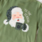 Green sweatshirt with a graphic of Santa Claus holding a mug and 'Tis the Season text on a white background.