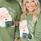 Two people wearing green sweaters with a Santa Claus graphic and 'Tis the Season' text.