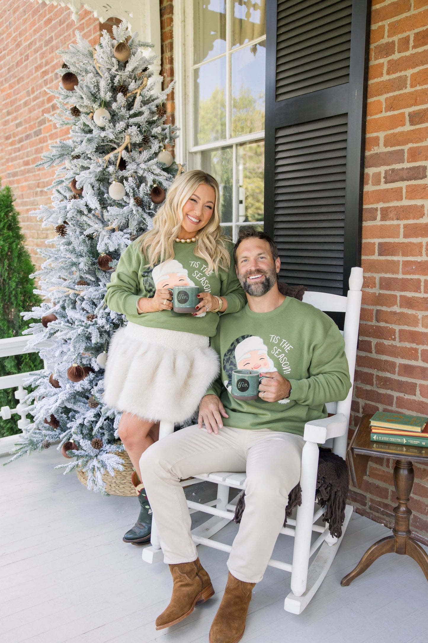 Couple sitting on a porch with a decorated Christmas tree in the background