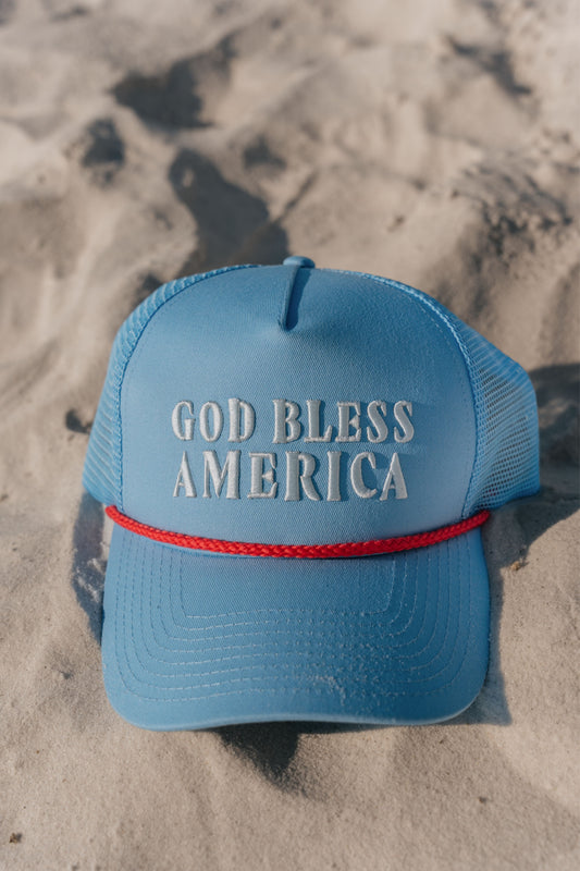 blue hat with god bless america on the front on the beach 