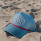 blue hat with god bless america on the front on the beach 