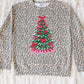 Leopard print sweater with a Christmas tree design on a textured surface