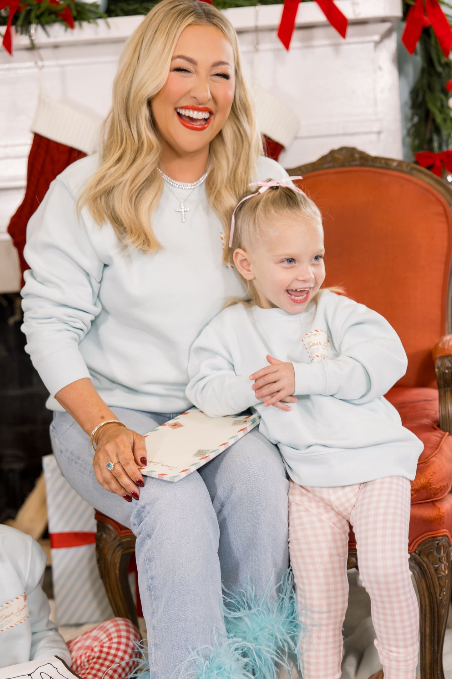 Woman and child sitting together in a festive setting with Christmas decorations.