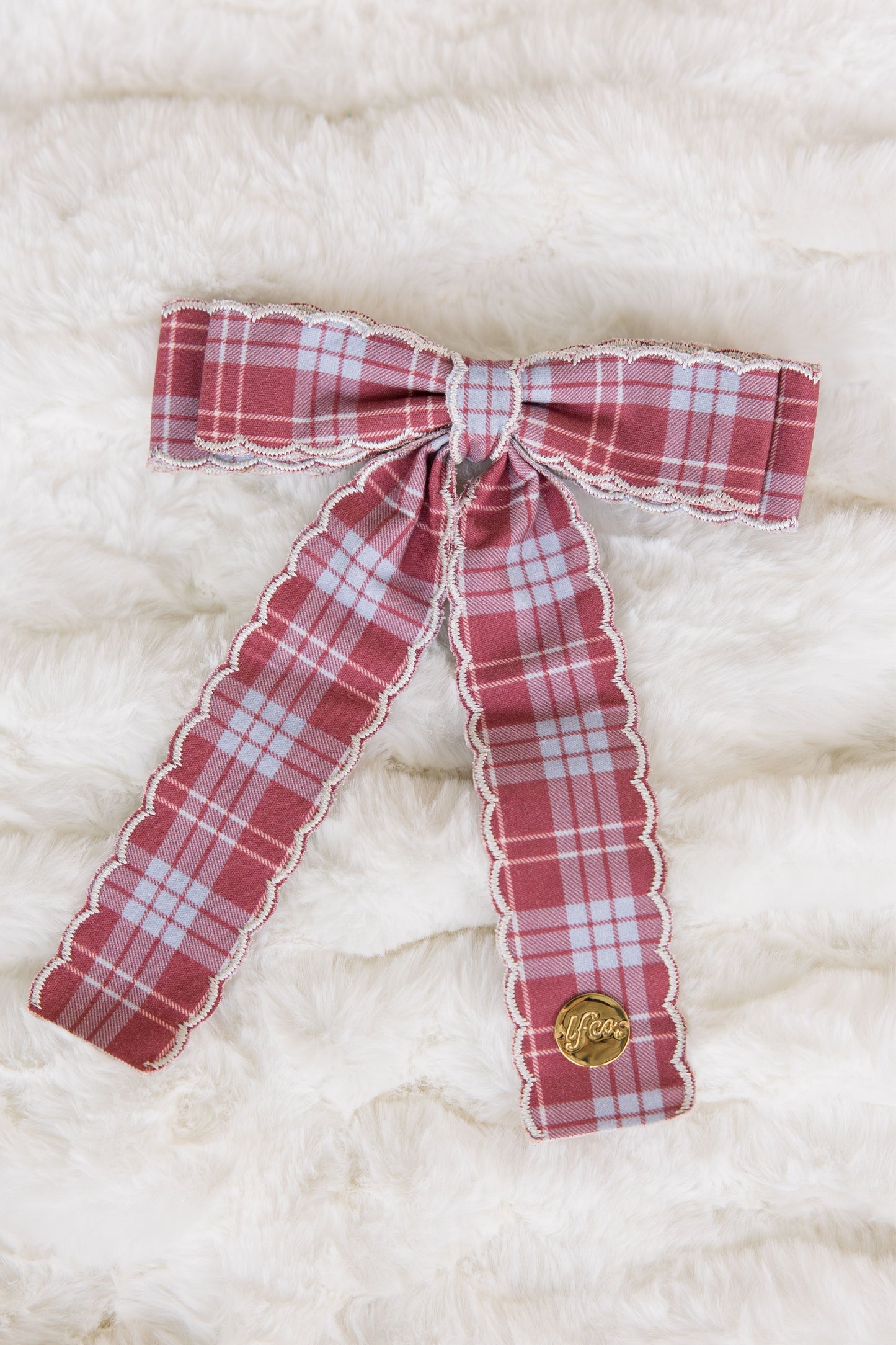 Red and white plaid bow on a textured white background