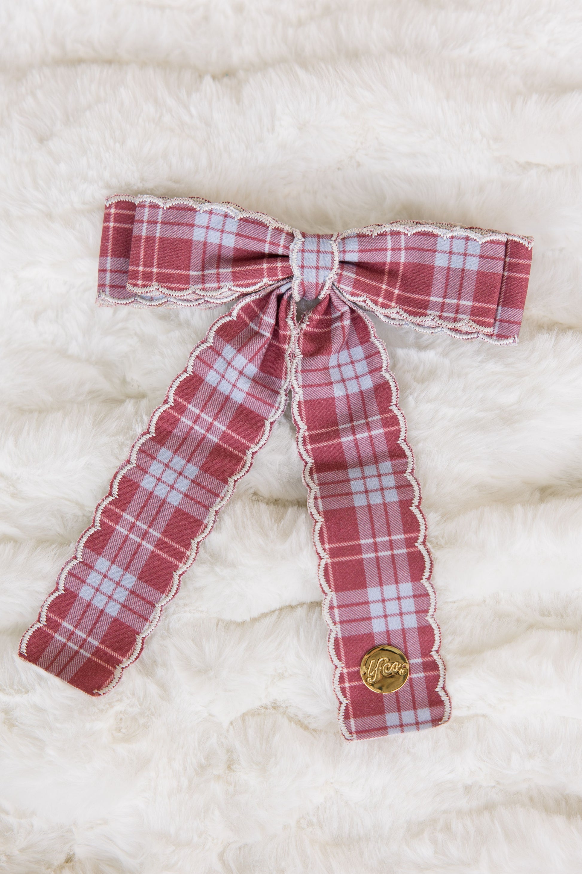 Red and white plaid bow on a textured white background