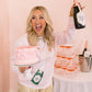 Woman holding a cake and a bottle of champagne in a celebratory setting.