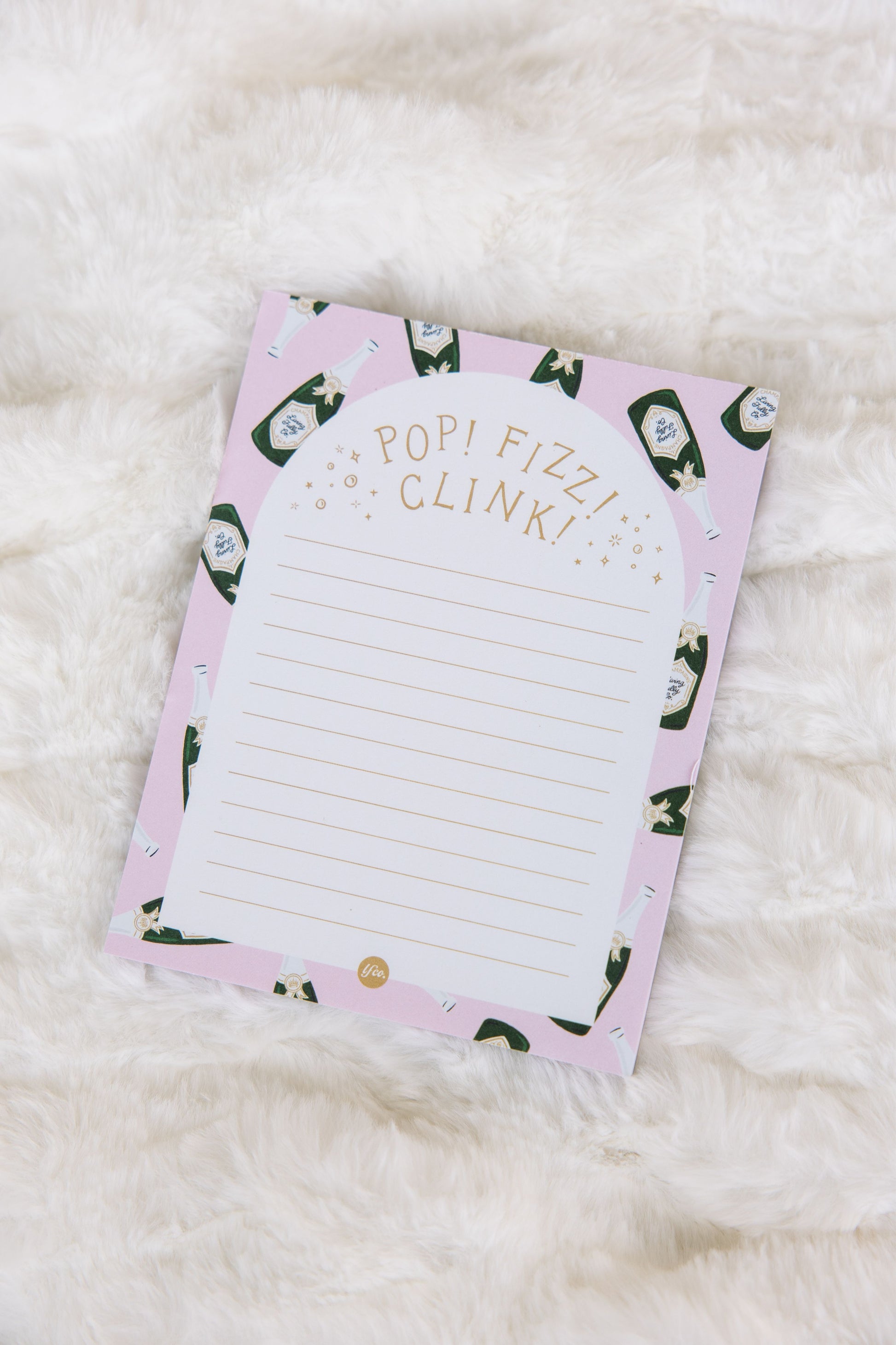 Notepad with a pink design and text on a white surface