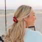 red clip with stones in blonde woman's hair