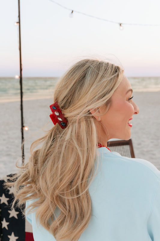 red clip with stones in blonde woman's hair